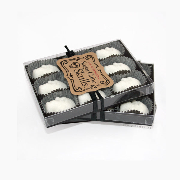 two stacked black boxes, sugar cube skulls, aligned in box, kraft label, white back ground.